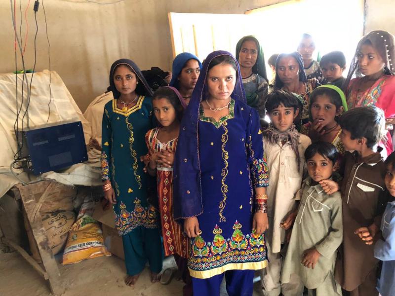 Women and children of the village of the village of Murid Khoso in Sindh province's Sujawal district, Pakistan, pose beside their prized possession -- battery hub with in-built charge controller, December 26, 2017. Thomson Reuters Foundation/Zofeen Ebrahim