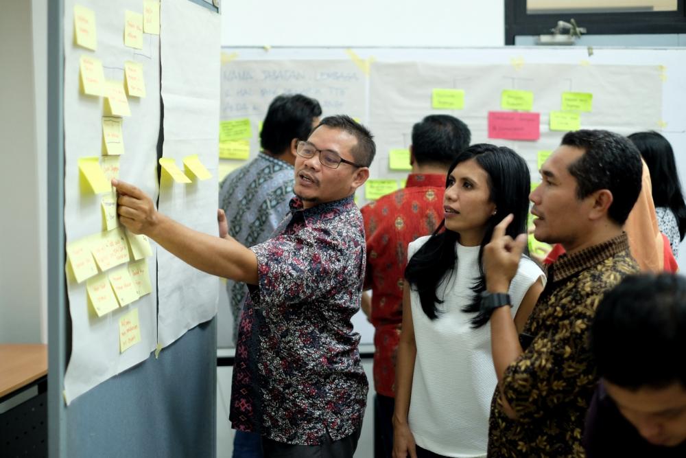 Workshop participants were discussing their problem tree analysis and explaining their logic to the facilitator. (Picture credit: Nyoman Prayoga, ACCCRN)